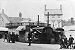 Carousel powered by traction engines in the Market Place, school boys looking on