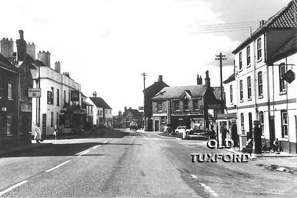 Looking towards the Market Place, Sanderson's garage at right, lollipop lady outside the Sun Inn